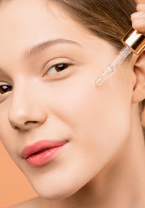 A woman applying a glycolic acid peel to her radiant face