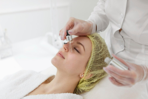 Applying glycolic acid peel into the woman's face