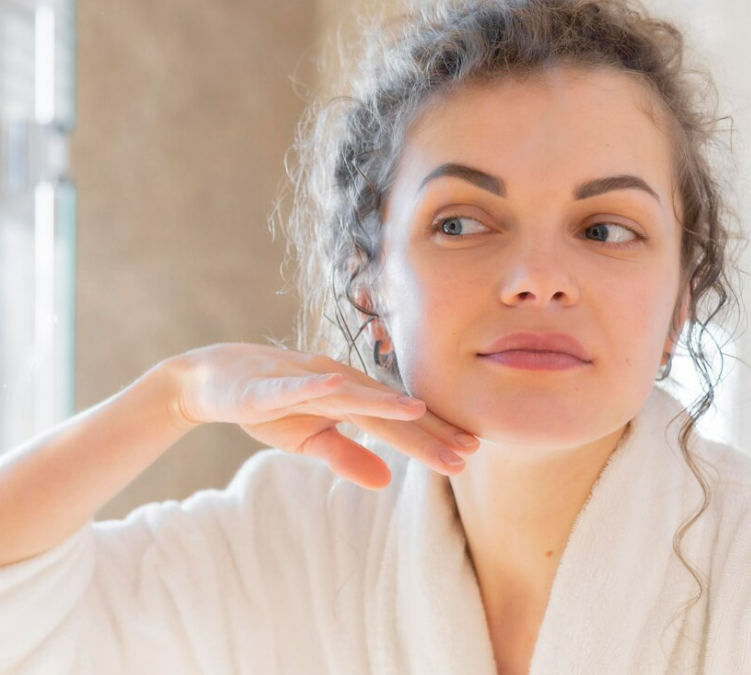 A woman checking her skin on her face